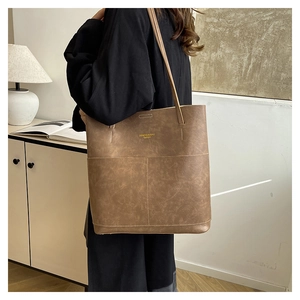 Detailed view of vintage brown leather tote bag with elegant texture and gold logo
