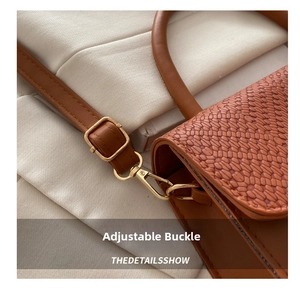 Detail view of the brown leather bag featuring snake skin texture and gold buckle