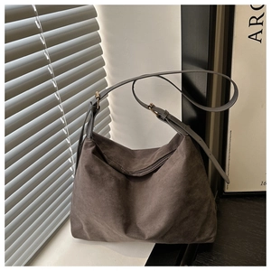 Detailed view of the dark grey faux suede hobo bag with a zipper and adjustable strap