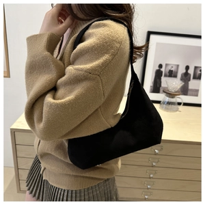 Detail of a black hobo shoulder bag featuring minimalist lines and a metal zipper closure