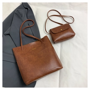 Close-up of retro brown leather tote set with vintage texture and golden logo details