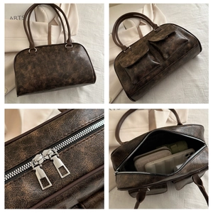 Dettaglio borsa a mano retrò in ecopelle marrone con cerniere argentate e tasche multiple