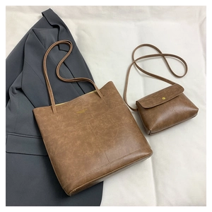 Detail view of large brown oil-wax leather tote and matching shoulder bag set