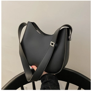 Detail of a black crescent shoulder bag featuring matte leather and silver square buckle
