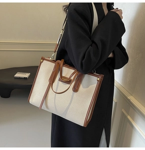 Détail d'un sac cabas en toile avec lanières en cuir marron et finitions dorées chics