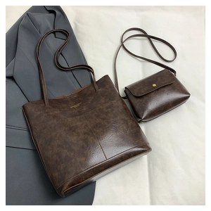 Detail view of deep brown vintage leather tote bag set with branded gold lettering