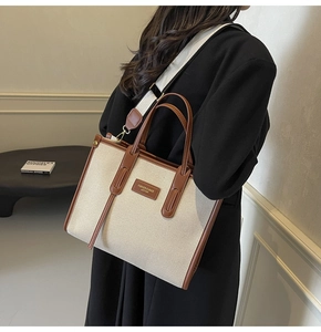 Vue latérale d'un grand sac fourre-tout en toile avec finitions en cuir brun sur modèle