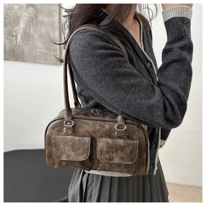 Dettaglio borsa sottobraccio in pelle marrone vintage con doppie tasche frontali e zip argento