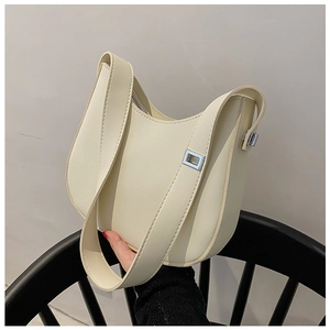 Detail view of a cream-colored leather baguette bag with silver hardware and shoulder strap