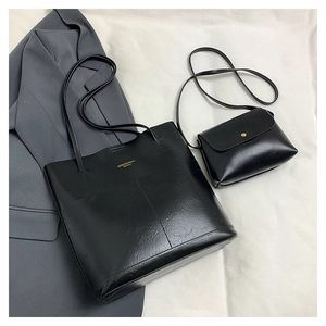 Detail of black faux leather tote bag and flap envelope clutch with gold magnetic buckle