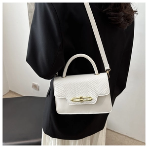 Rear view of a model carrying a white minimalist square handbag with gold metal lock