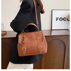 Detail view of brown vintage tote bag with gold buckles and adjustable shoulder strap
