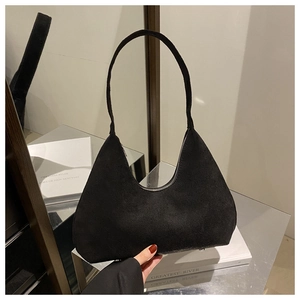 Detail shot of black suede hobo bag with smooth silver zipper and minimalist shoulder strap
