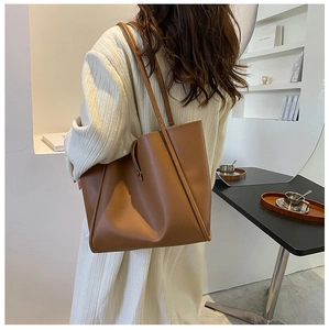 Close-up of caramel leather tote bag showing soft PU texture and double shoulder straps