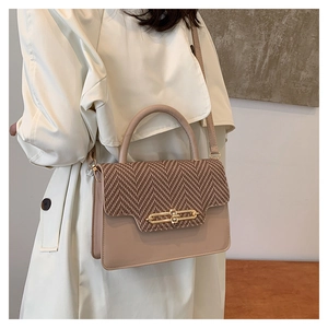 Detail of crossbody bag featuring beige leather and brown herringbone fabric textures