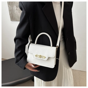 Detail of white vintage square bag showing mixed leather textures and gold metal buckle