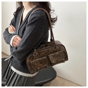 Dettaglio della borsa tote vintage marrone scuro con due tasche frontali sul modello