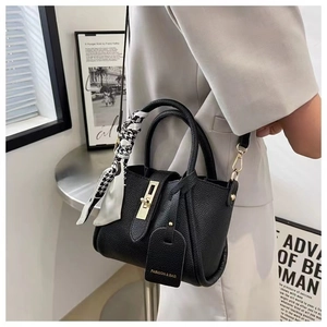 Detail of black lychee leather bucket bag with houndstooth scarf and golden twist lock