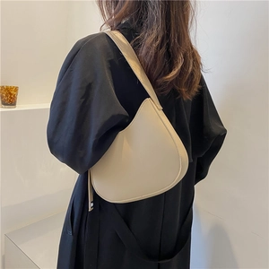 Minimalist cream white half-moon shoulder bag in smooth faux leather on model