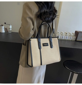 Détail du sac cabas en toile avec bordure en cuir noir et bandoulière réglable