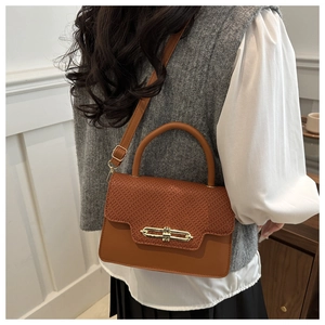 Detail of vintage caramel crossbody bag with animal print texture and gold lock