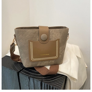 Detail of retro brown bucket bag with textured contrast pocket and Fashion & Bags text