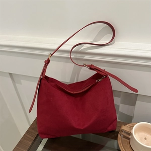 Deep red suede hobo shoulder bag with adjustable leather strap and gold zipper closure