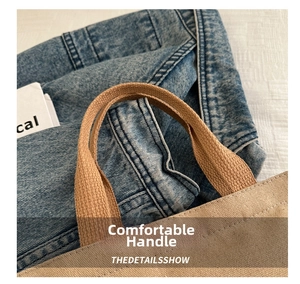 Detail of khaki canvas bag with wide flat handle and reinforced stitching