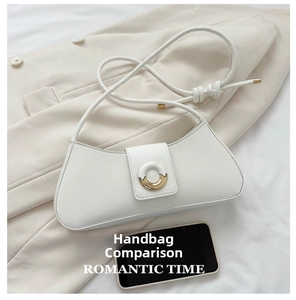 White minimalist underarm bag with gold buckle shown next to phone for size comparison