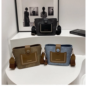 Trio of bucket bags in black, green, and blue with gold beaded trim and wide fabric straps