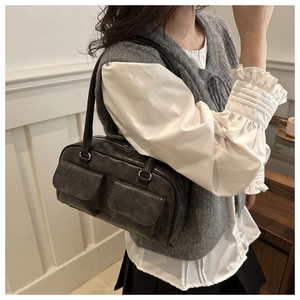 Dettaglio di una borsa a spalla grigia vintage con doppie tasche frontali a patta