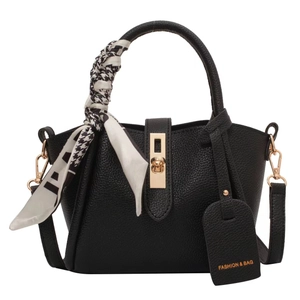 Black lychee leather bucket bag with gold lock, silk scarf handle, and crossbody strap