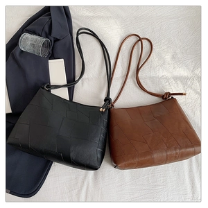 Detailed shot of two-tone geometric tote bags with rope straps on white fabric