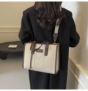 Vue arrière du mannequin avec un cabas en toile beige, garniture en cuir et bandoulière large