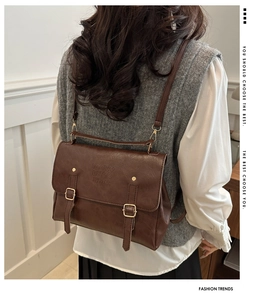 Detail view of dark brown vintage faux leather backpack with metallic buckle closures