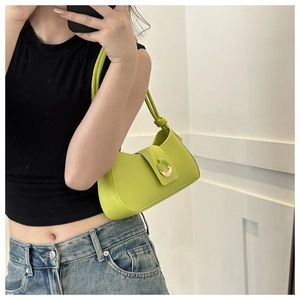 Close-up of vibrant neon green leather baguette bag with gold hardware and knotted strap