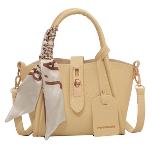 Chic creamy yellow bucket bag with lychee grain texture and decorative silk scarf wrap