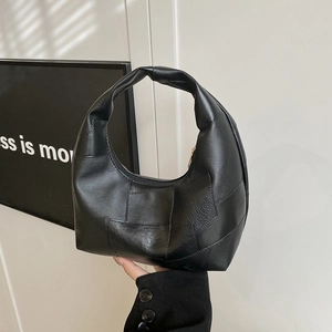 Minimalist black pleated cloud bag with textured leather stitching and a gold zipper