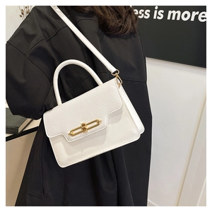 White leather handbag with woven flap and gold lock shown on model with black coat