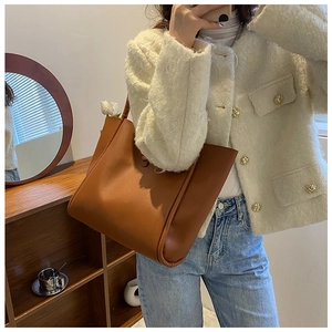 Classic brown large capacity tote bag shown being worn over the shoulder for size scale