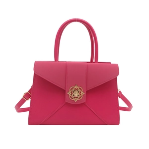 Minimalist hot pink shoulder bag with gold filigree clasp and adjustable strap