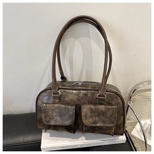 Dettaglio della borsa vintage marrone scuro con trama screpolata e due tasche anteriori