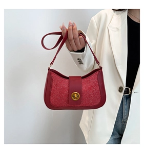 Close-up of red tweed handbag with gold rotary lock and leather trim detail