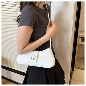 Chic white leather underarm bag with gold circular metal buckle worn on the shoulder