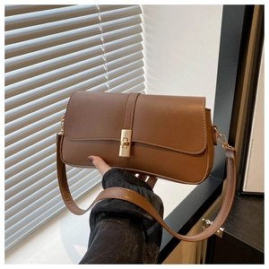 Gros plan du sac à main marron vintage avec fermoir doré et texture en cuir lisse