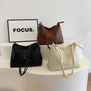 Three minimalist tote bags in black, brown and beige featuring geometric patchwork design