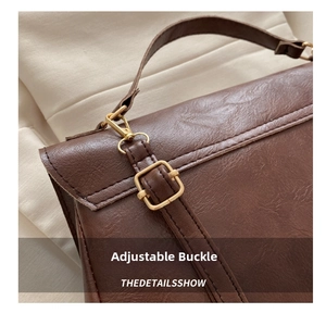 Detail shot of the adjustable gold metal buckle and brown vintage leather texture