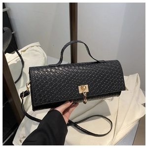 Close-up of black woven texture handbag with golden square lock and metal hardware