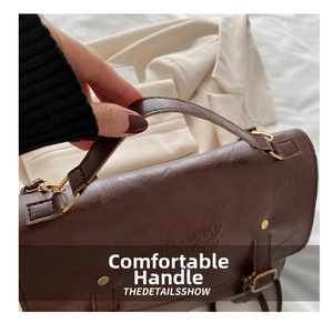Close-up of deep brown pebbled leather texture with embossed Lucky text and gold hardware