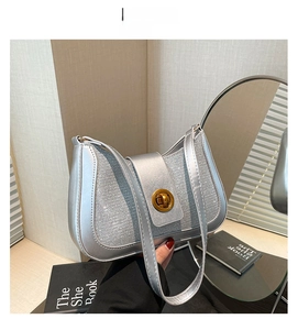Detail of silver glitter fabric shoulder bag with light gold turn-lock closure